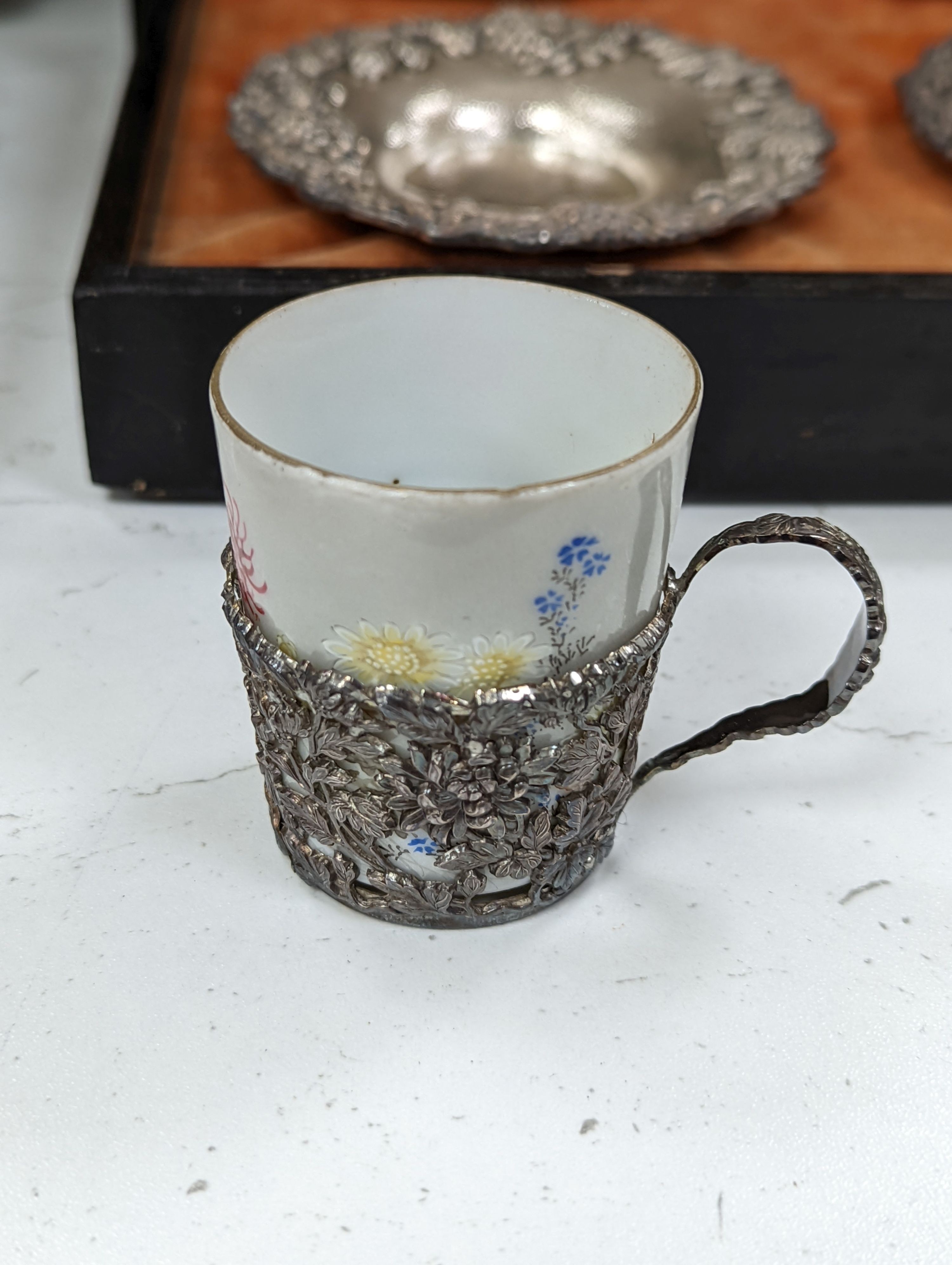 A cased Japanese white metal and eggshell porcelain six piece coffee set, maker’s mark only, case 39.5 cm wide